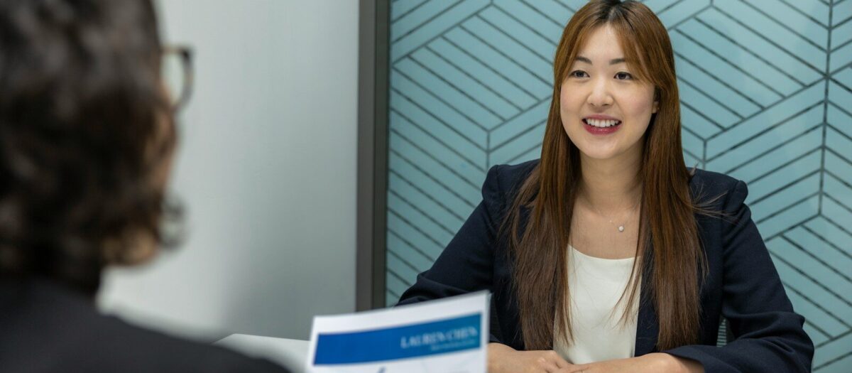 How to Prepare for an Internship Interview a woman sitting at a table with a piece of paper in front of her