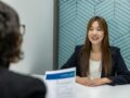 How to Prepare for an Internship Interview a woman sitting at a table with a piece of paper in front of her