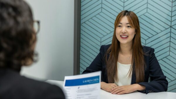 How to Prepare for an Internship Interview a woman sitting at a table with a piece of paper in front of her