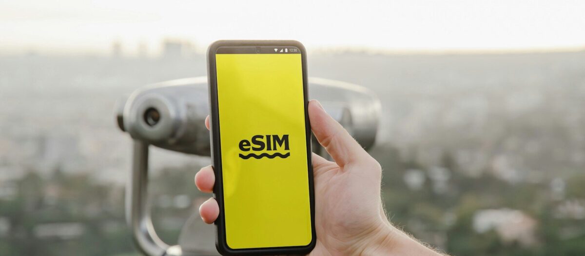 esim a person holding up a cell phone with a logo on it