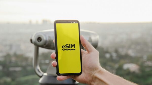 esim a person holding up a cell phone with a logo on it